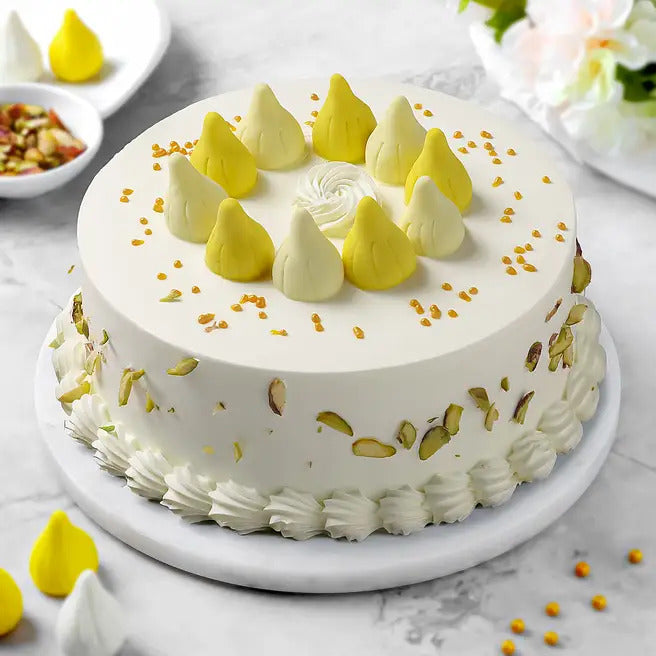 Divine Modak butterscotch cake with modak-style toppings and pistachio garnish