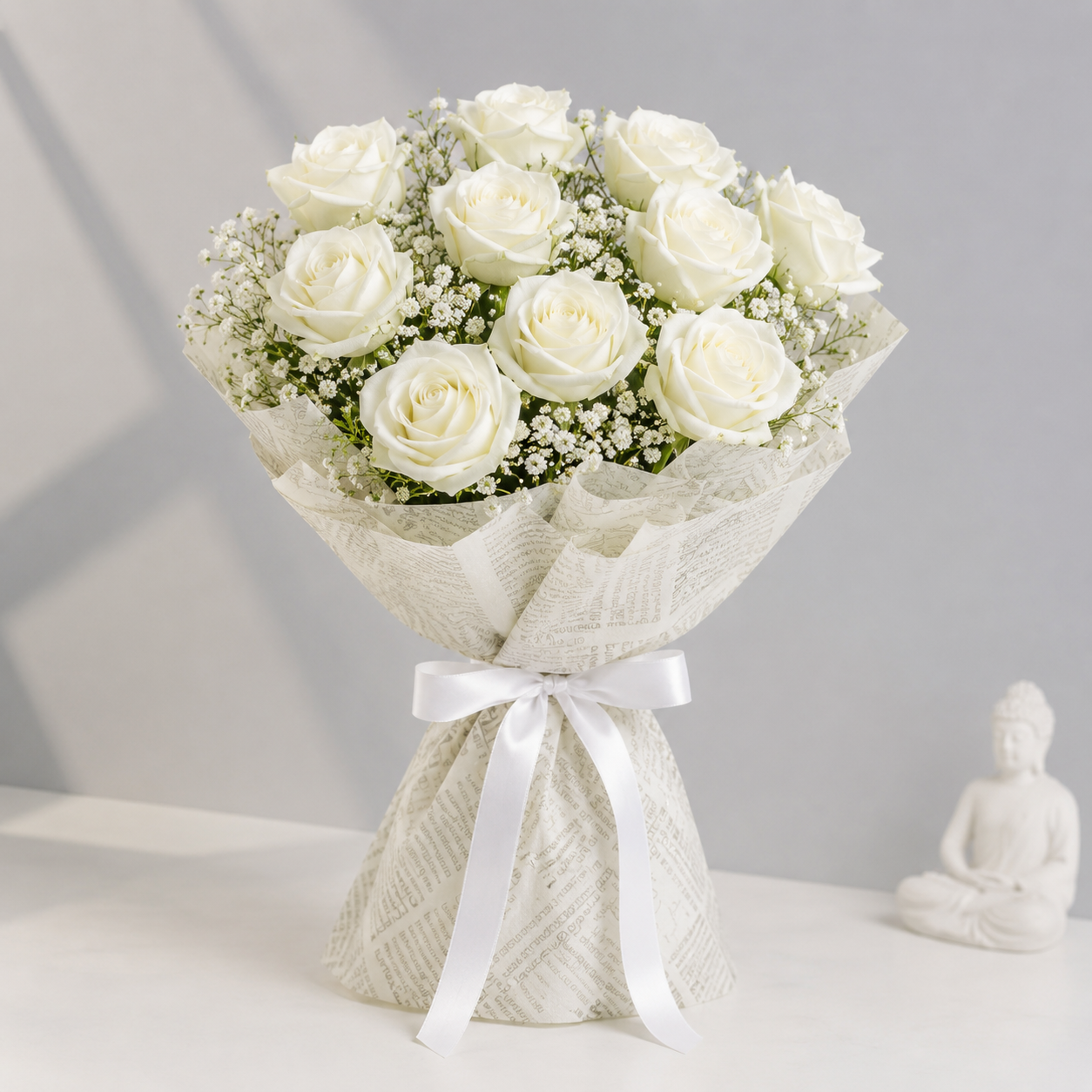 Moonlit Purity white roses bouquet with baby’s breath and cream printed wrapping