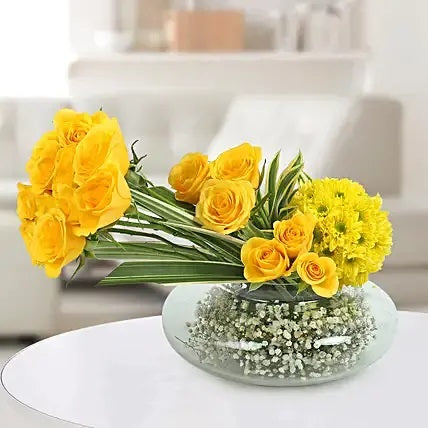 Yellow roses bowl arrangement with baby’s breath and green leaves for flower