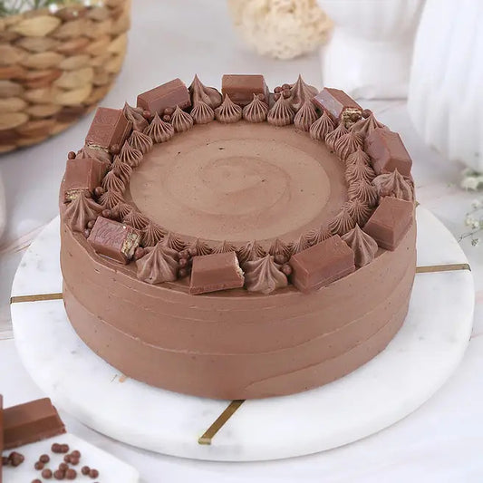 Cocoa Crunch chocolate cake with chocolate bar pieces and cream swirls