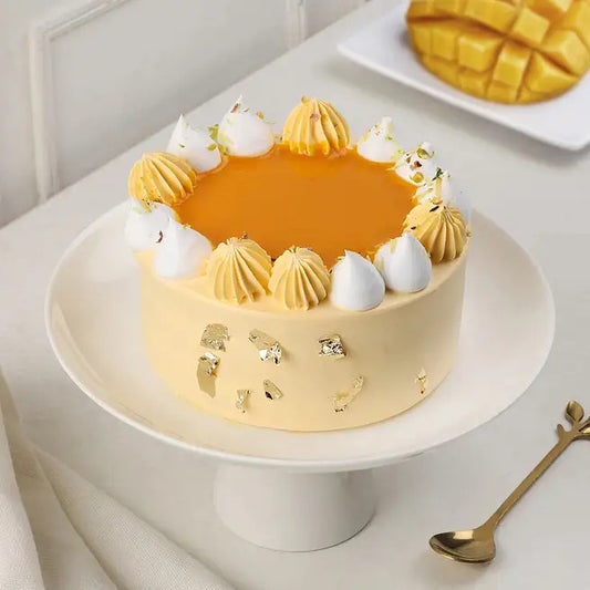 Mango Gleam cream cake with mango glaze, cream swirls and gold leaf decoration