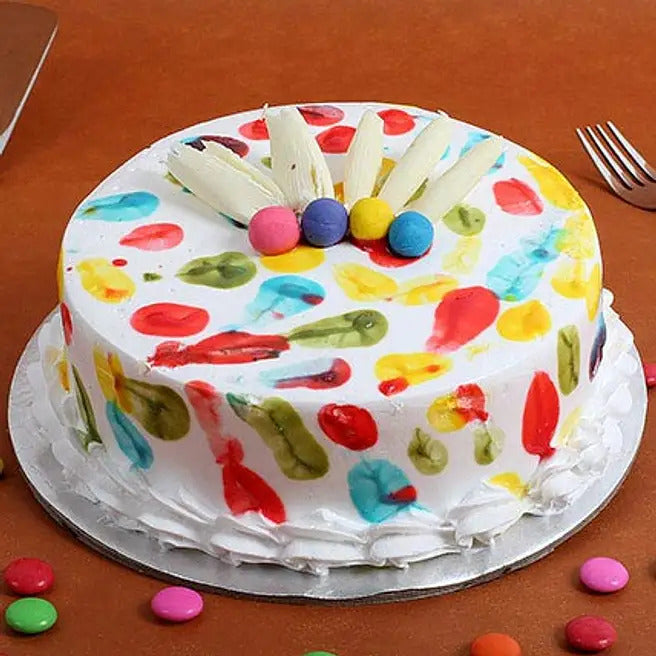 Rangoli Delight colourful pineapple cake with white chocolate garnish and candy topping
