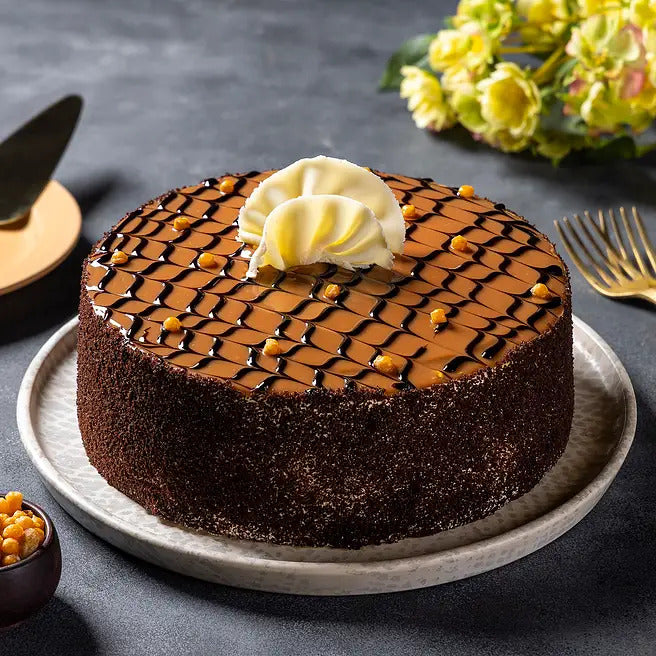 Toffee Mosaic butterscotch cake with caramel chocolate lattice and white chocolate garnish