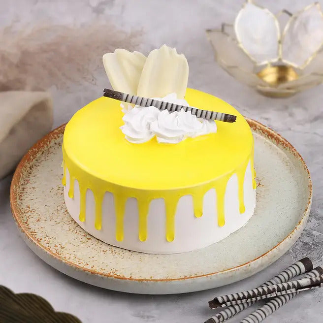 Tropical Drip pineapple cake with yellow drip glaze, white cream and chocolate garnish