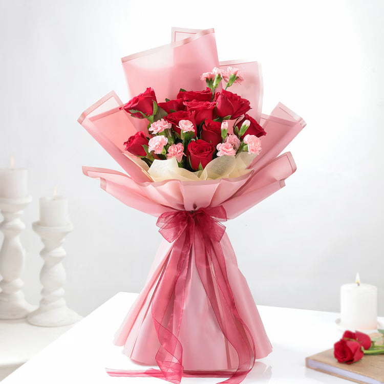 Red roses with pink carnations bouquet in pink wrapping for romantic gift delivery