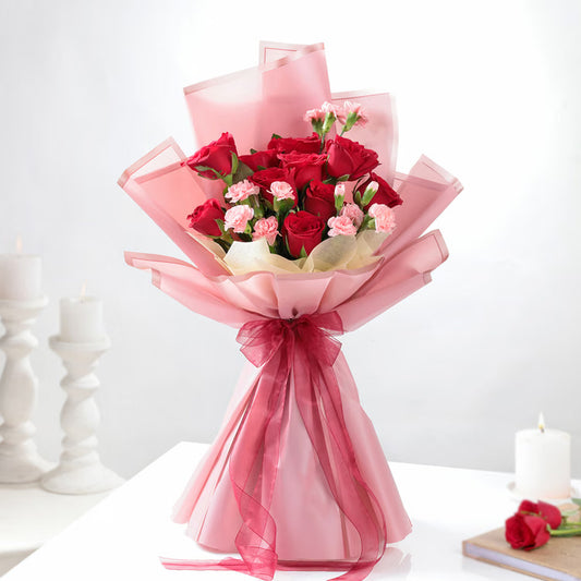 Red roses with pink carnations bouquet in pink wrapping for romantic gift delivery