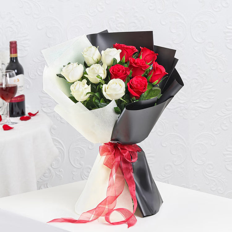 Red and white roses bouquet in black and white wrapping with red ribbon for gift delivery