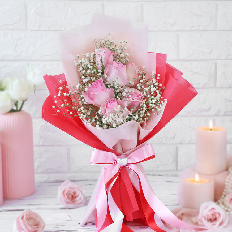 Fresh pink roses bouquet with baby’s breath in red and pink wrapping for gift delivery