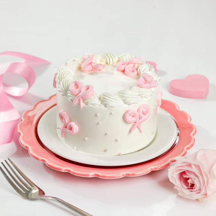 Pink bow mini cake with white cream and pearl decoration for same day delivery India