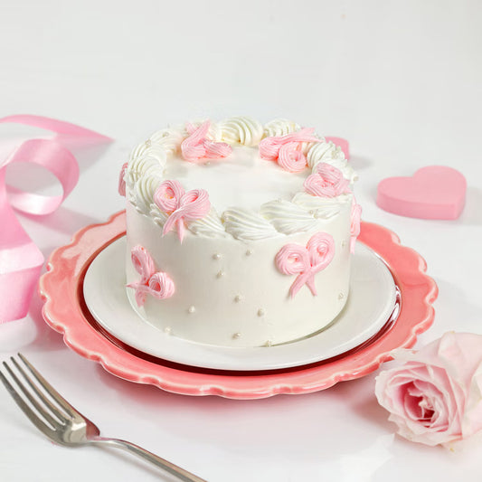 Pink bow mini cake with white cream and pearl decoration for same day delivery India