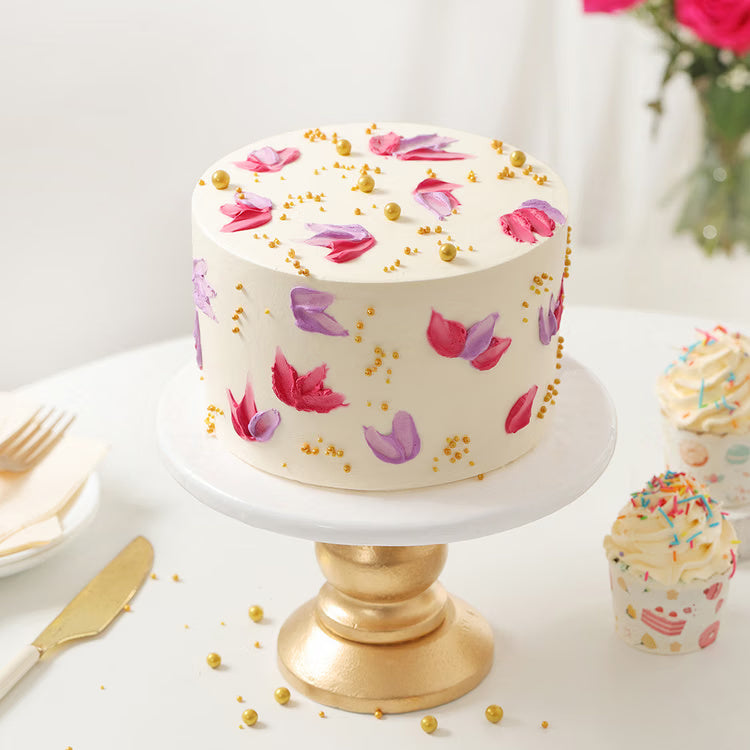 Floral cream cake with pink purple petals and golden pearls for cake delivery India