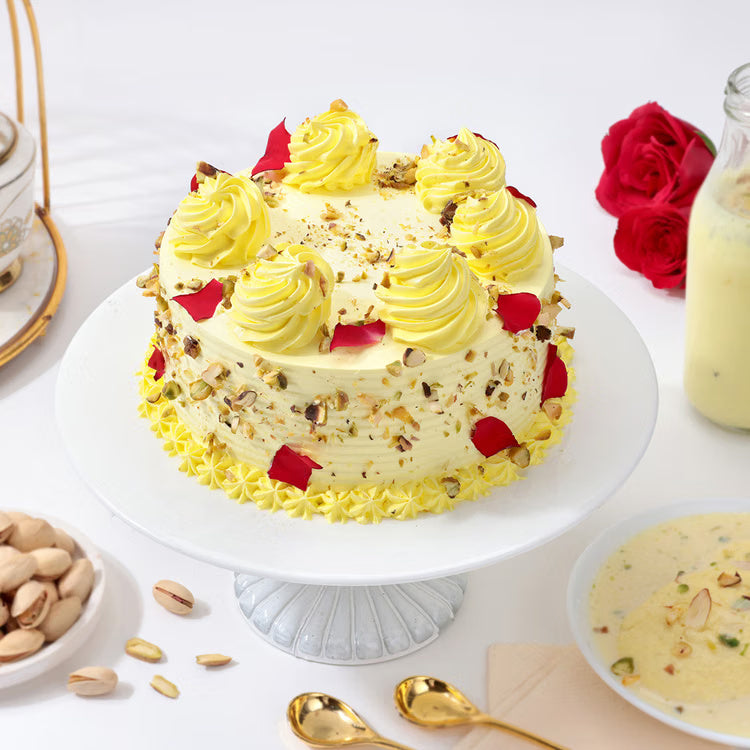Rasmalai cake with pista garnish rose petals and cream swirls for birthday and festive celebration
