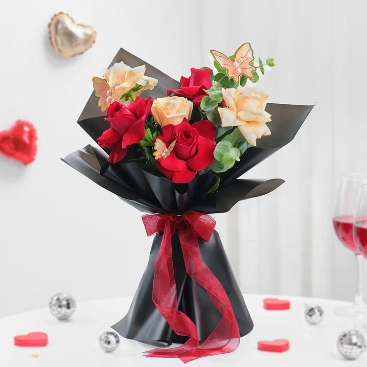 Fresh red and peach roses bouquet with butterfly decoration for anniversary and romantic gift