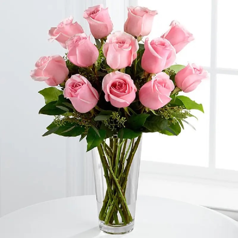 Elegant fresh pink roses arranged in a glass vase, perfect for birthdays, anniversaries and thoughtful surprises. Fresh pink roses in glass vase for birthday anniversary and love gift