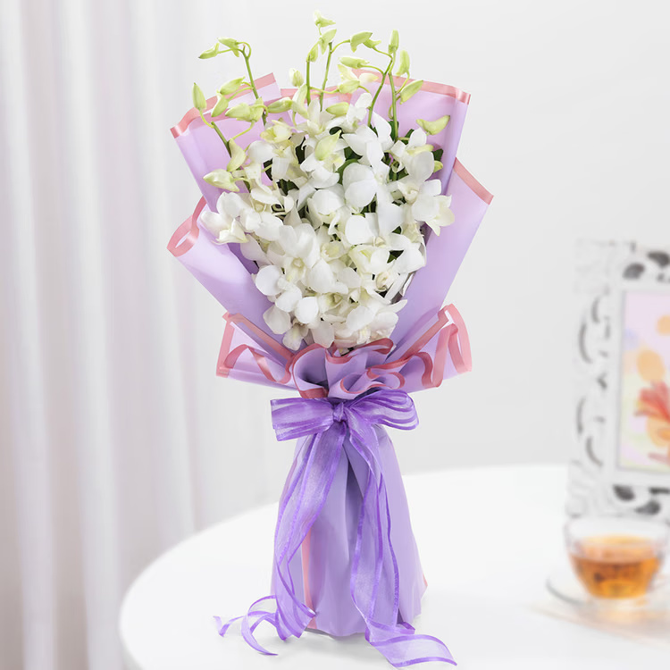 A premium white orchid bouquet in lavender wrapping for birthdays, anniversaries and elegant gifting. White orchid bouquet in lavender wrapping for same day flowe