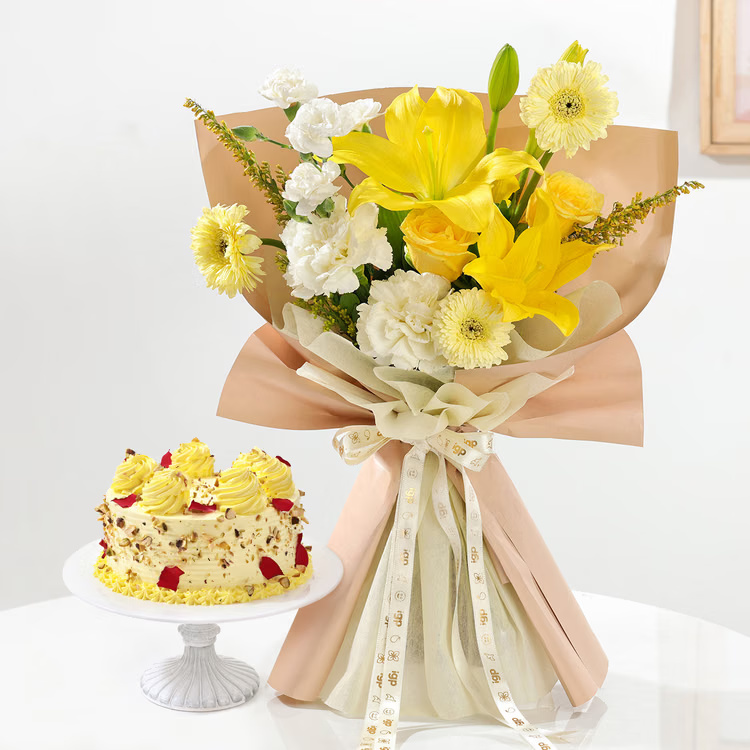 Fresh yellow lilies, roses and white flowers paired with a delicious Rasmalai cake for cheerful celebrations. Yellow lilies and roses bouquet with Rasmalai cake for birthday anniversary and festive gift