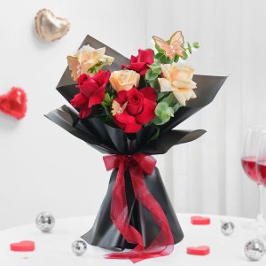 Fresh red and peach roses bouquet with butterfly decoration for anniversary and romantic gift